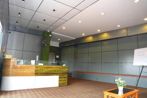 a lobby with a reception desk and a tree at Hotel Kakatiya Pride in Warangal