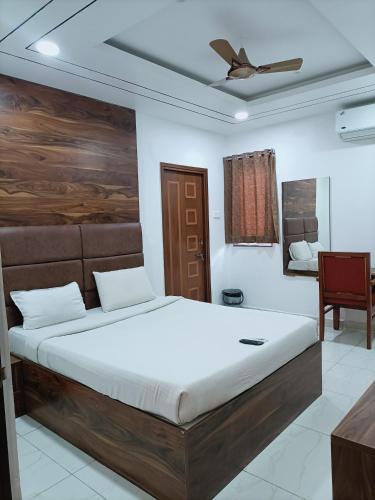 a bedroom with a large bed with a ceiling at Hotel Kakatiya Pride in Warangal