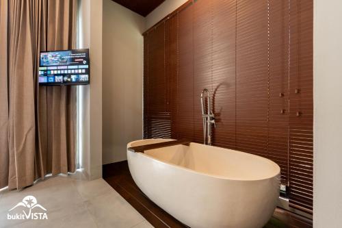 a large bath tub in a bathroom with a tv at Soocha B by Bukit Vista in Ungasan