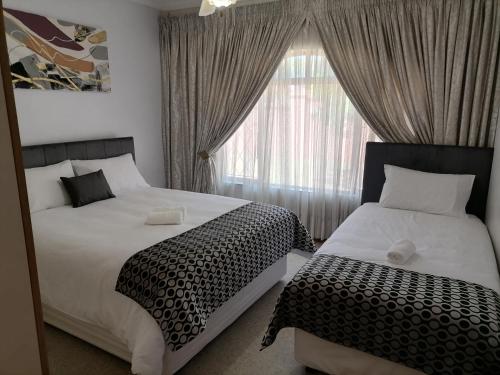 een slaapkamer met twee bedden en een raam bij 850 Munro in Margate