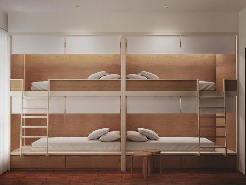 een kamer met 3 stapelbedden met witte kussens bij ClubRock Perlis in Kaki Bukit