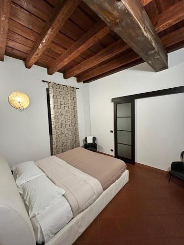 a bedroom with a large bed and a wooden ceiling at La Corte Dei Cappuccini in Bergamo