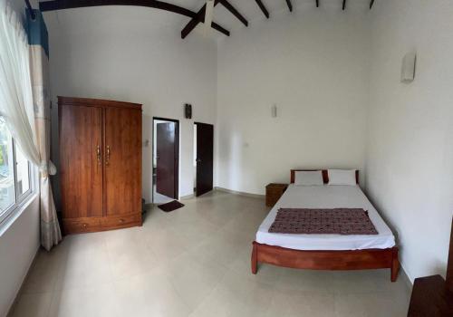 ein Schlafzimmer mit einem Bett und einem Holzschrank in der Unterkunft A&J Rest House 