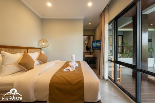 a bedroom with a bed with a stuffed animal sitting on it at Soocha C by Bukit Vista in Ungasan
