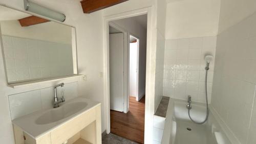 a white bathroom with a sink and a shower at La Rollinoise in Valsonne