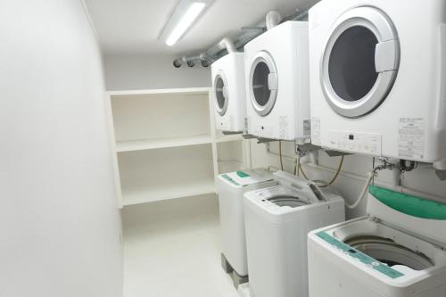 a laundry room with washing machines and a washer and dryer at 還元ホテル 名護東江 in Nago