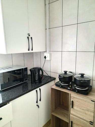 a kitchen with two pots and pans on a stove at Visitors' Paradise Guest House in Newcastle