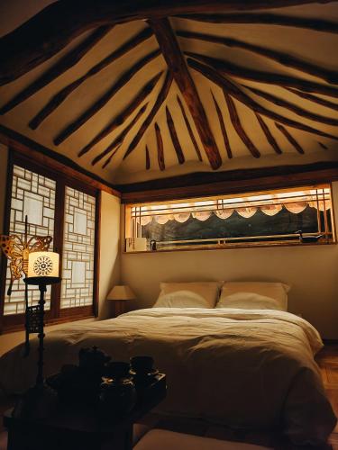a bedroom with a large bed and two windows at 사다함 SaDaHam in Gyeongju
