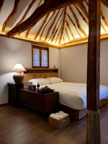 a bedroom with a bed and a desk with a lamp at 사다함 SaDaHam in Gyeongju
