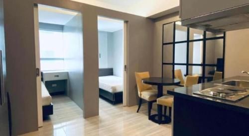 a room with a kitchen and a bedroom with a table at Lancaster Hotel Manila in Manila
