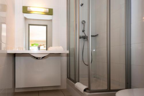 een badkamer met een douche en een wastafel bij ibis budget Nimes Marguerittes - A9 in Marguerittes