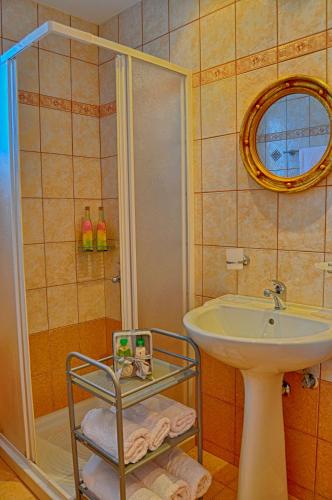 a bathroom with a sink and a shower at Pyrgos Zante Suites in Alikanas