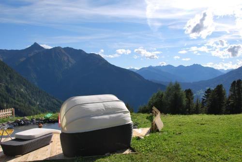 a boat sitting on a field with mountains in the background at Berggasthof Hochzeigerhaus in Jerzens