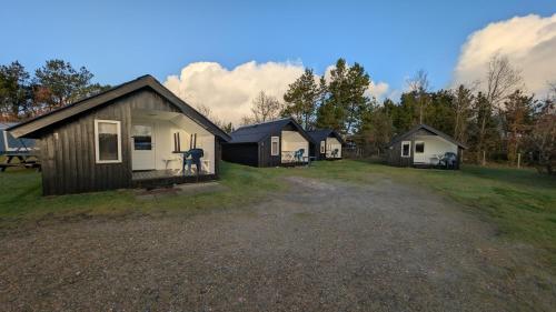 a group of small houses in a field at Henneby Camping - hytter in Henne Strand