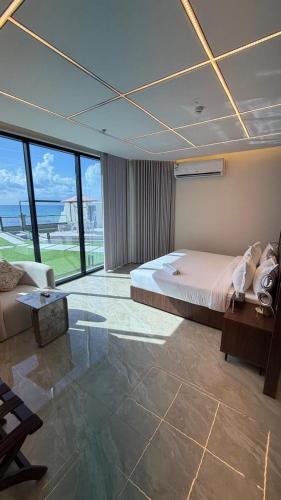 una camera da letto con un letto, un divano e finestre di شاليهات ستارفيش a Umm Lajj