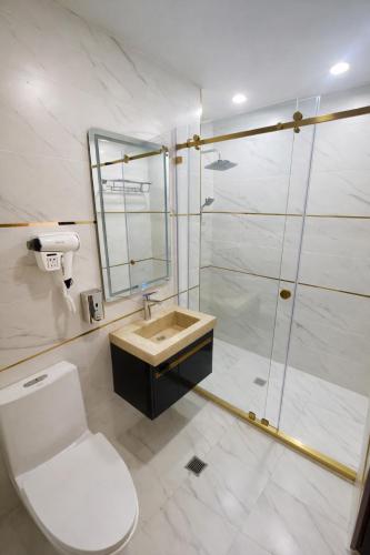 a bathroom with a toilet and a sink and a shower at BALAND HOTEL DUSHANBE in Dushanbe