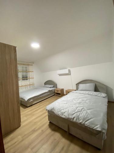 a bedroom with two beds and a lamp in it at Rakocevic house in Kolašin