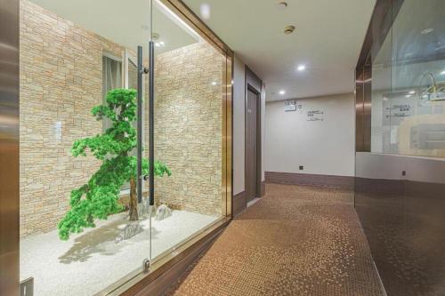 ein Zimmer mit einer Glastür mit einer Pflanze darin in der Unterkunft Hi Inn Shanghai Zhongshan Park Branch in Shanghai