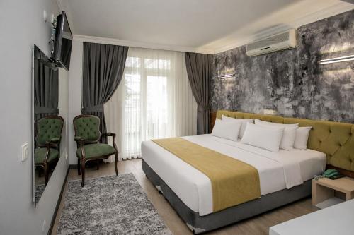 a hotel room with a bed and a chair at Hotel Pera Capitol - Taksim & İstiklal in Istanbul