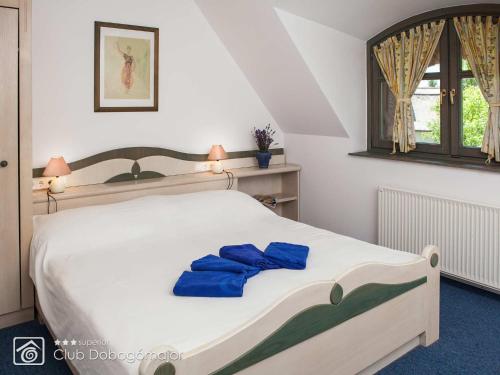 Un dormitorio con una cama con toallas azules. en Club Dobogómajor superior en Cserszegtomaj