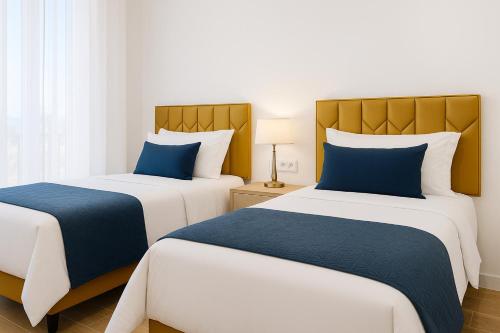 2 letti in camera d'albergo con cuscini blu di La Soleá Historic Center a La Herradura