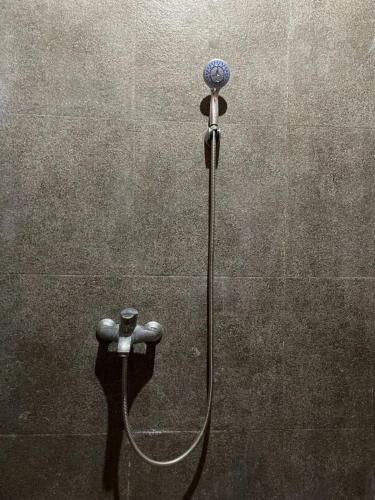 a shower with a hose attached to a wall at Villa Azzyra in Pakem