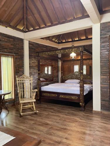 a bedroom with a large bed and a chair at Villa Azzyra in Pakem