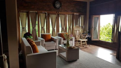 een woonkamer met witte banken en een tafel bij Villa Azzyra in Pakem