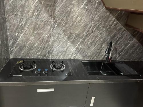 een zwart aanrecht met een wastafel in de keuken bij Villa Azzyra in Pakem