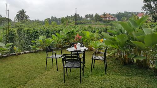 un tavolo e sedie in un cortile con prato di Villa Azzyra a Pakem