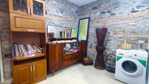 een wasmachine in een kamer met een stenen muur bij Julia's Village Villa in Korçë