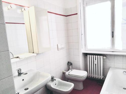 a bathroom with a sink and a toilet and a window at Charming Central Relais in Bergamo