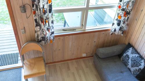 a small room with a couch and a window at Silkeborg Sø Camping Apartments in Silkeborg