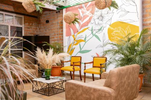 a room with chairs and a wall with plants at Botánica Casa Hotel in Medellín