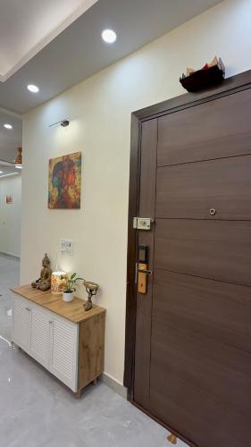 a large brown door in a room with a table at NIVAASe STAYS in New Delhi