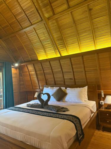 een slaapkamer met een bed met een zwaan erop bij Lumbung Intan in Sidemen