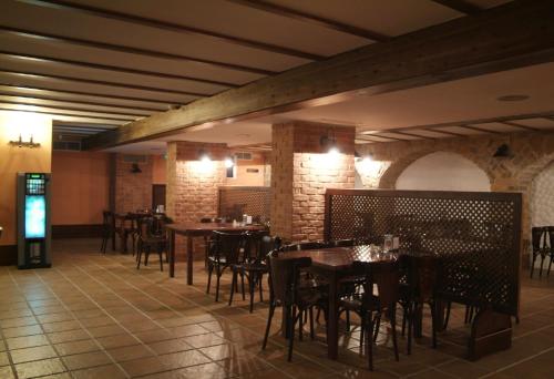 ein Restaurant mit Tischen und Stühlen in einem Zimmer in der Unterkunft Hotel Cervantes in Zafra