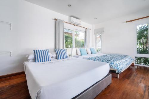 ein weißes Schlafzimmer mit einem großen Bett und einer Couch in der Unterkunft Sorrento Pool Villa Bang Lamung Pattaya in Ban Rong Po