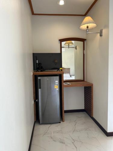 een kleine koelkast in een kamer met een spiegel bij บ้านพิมพ์วนาเขาใหญ่ ห้องมินิ in Ban Tha Maprang
