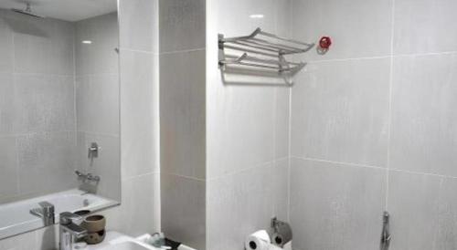 a bathroom with a sink and a toilet and a mirror at Hotel Scholar's Suites in Kampong Jalan Berop