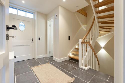 een hal met een trap en een witte deur bij Dünenhafer in List