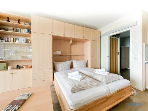 een slaapkamer met een groot bed met houten kasten bij Haus Nautic Wohnung 615 in Döse