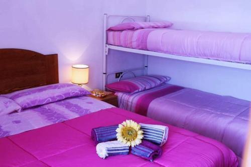 twee bedden in een kamer met roze lakens bij Appartamento Il Bosco Incantato in Abetone