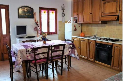 een keuken met een tafel en stoelen en een keuken met een fornuis bij Appartamento Il Bosco Incantato in Abetone