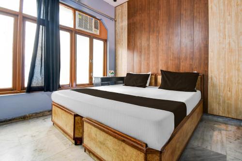 a bedroom with a large bed with wooden walls and windows at HOTEL O STAY INN Lucknow Airport VIP Terminal in Transport Nagar