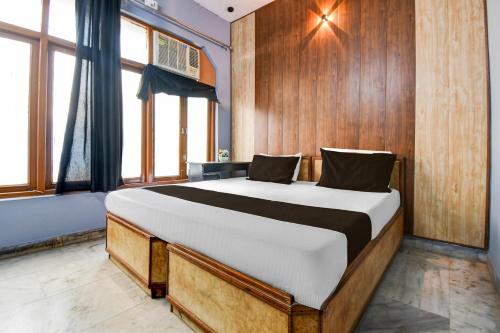 a bedroom with a large bed with wooden walls and windows at HOTEL O STAY INN Lucknow Airport VIP Terminal in Transport Nagar