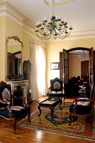 a living room with chairs and a chandelier at Pazo Almuzara in Boborás