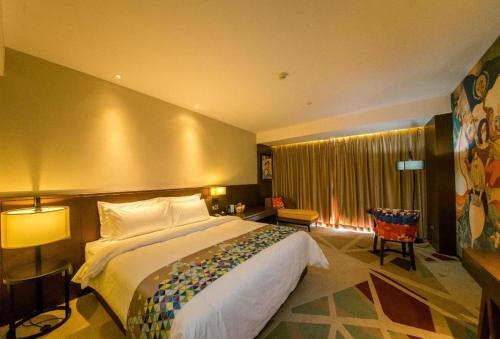 Una habitación de hotel con una cama grande y una ventana. en Zmax Changzhi Bayi Square, en Changzhi