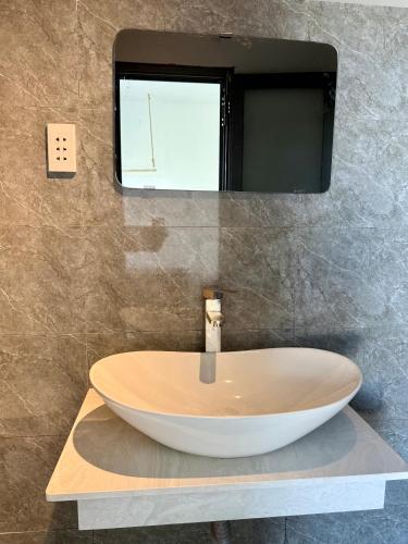 uma casa de banho com um grande lavatório num balcão em T-Homestay Bình minh xanh 