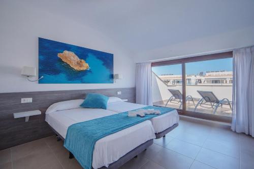 a hotel room with a bed and a large window at Aparthotel Ferrer Skyline in Ciutadella